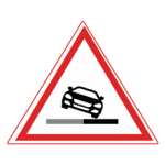 Pakistani cautionary road sign showing a vehicle tipping at the edge of the road surface inside a red-bordered triangle